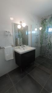 a bathroom with a sink and a shower with a mirror at MyHome Olhão in Olhão