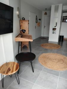 a room with two tables and a chair and a tv at Appartement aux Minimes in La Rochelle