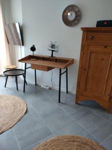 une chambre avec une table et une horloge sur le mur dans l'établissement Appartement aux Minimes, à La Rochelle