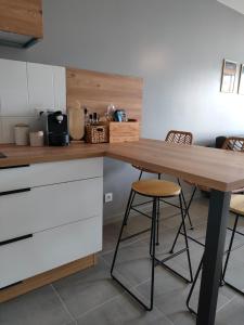 une cuisine avec une table en bois et deux tabourets dans l'établissement Appartement aux Minimes, à La Rochelle