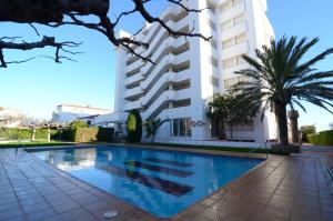 uma piscina em frente a um edifício em Apartamentos Front Mar em L'Escala