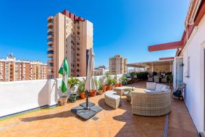 Un balcón con sofás y sillas en un edificio. en 797 HOLIDAY RENTALS - Atico duplex en Fuengirola con espectacular terraza, en Santa Fe de los Boliches