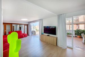 Una sala de estar con un sofá rojo y un televisor de pantalla plana. en 797 HOLIDAY RENTALS - Atico duplex en Fuengirola con espectacular terraza, en Santa Fe de los Boliches