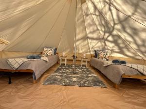 a tent with two beds and a table in it at Sambla majutus in Hiiumaa