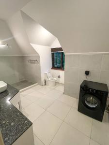 ein Badezimmer mit einer Waschmaschine und einem WC in der Unterkunft Nautilus Apartments in Mahé