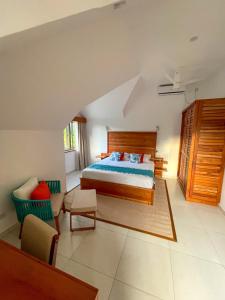 a bedroom with a bed and a couch and a chair at Nautilus Apartments in Mahe