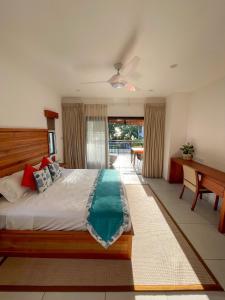 a bedroom with a large bed and a desk at Nautilus Apartments in Mahe