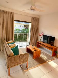 a living room with a couch and a television at Nautilus Apartments in Mahe