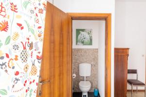 a bathroom with a toilet and a wooden door at Mestre Altamarea Apartment in Mestre