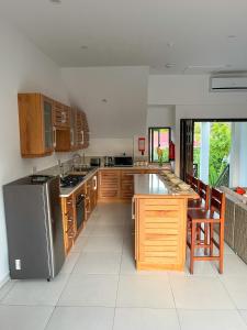 a kitchen with wooden cabinets and a stainless steel refrigerator at Nautilus Apartments in Mahe