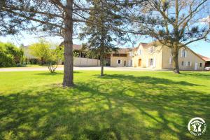 a large yard with trees in front of a house at Le Bila in Troncens