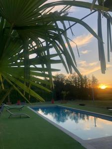 a swimming pool with a sunset in the background at Les Gites du Valjoly 2 in Touvent