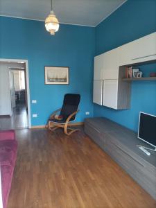 ein Wohnzimmer mit einem Stuhl und einer blauen Wand in der Unterkunft Casa Vacanze Litoranea in Follonica