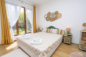 a bedroom with a bed and a large window at Guests house Provence in Kavarna