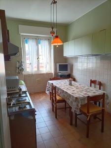 eine Küche mit einem Tisch mit Stühlen und einem Herd in der Unterkunft Casa Vacanze Litoranea in Follonica