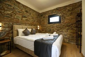 a bedroom with a bed and a stone wall at Mia Mia Suites in Istanbul