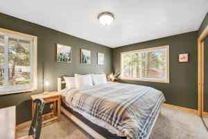 a bedroom with a bed and two windows at Country Club Cabin in Big Bear City