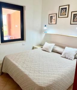 a bedroom with a large bed with a window at 20 steps from the beach in Costa Rei