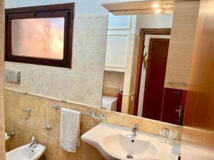 a bathroom with a sink and a mirror at 20 steps from the beach VILLINO STECU in Costa Rei +28 photos