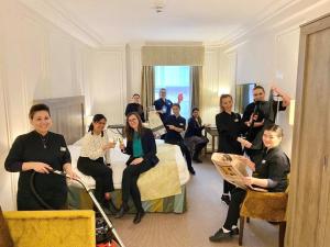 grupa ludzi siedzących w pokoju hotelowym w obiekcie Astor Court Hotel w Londynie