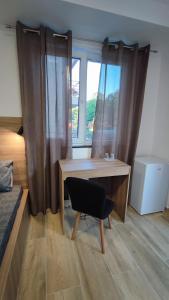 a bedroom with a desk and a chair in front of a window at Villa Natali in Ohrid