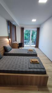 two beds in a large room with a window at Villa Natali in Ohrid