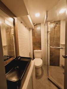 a bathroom with a toilet and a glass shower at Suraya Bangkok in Bangkok