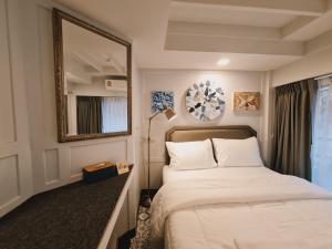 a bedroom with a large bed and a mirror at Suraya Bangkok in Bangkok