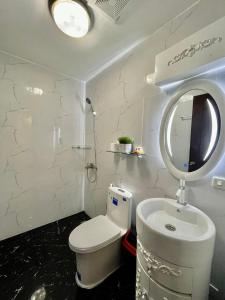 a bathroom with a toilet and a sink and a mirror at K-Residences Private Pool in Angeles
