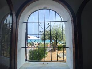 an arched window with a view of a yard at La Terrazza sull'Alba in Costa Rei