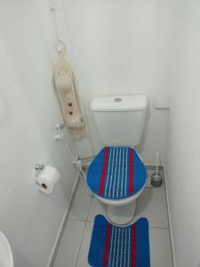 a bathroom with a toilet with blue and red mats at Lolita House in Rio de Janeiro