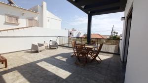 a patio with a table and chairs on a balcony at MyHome Olhão in Olhão
