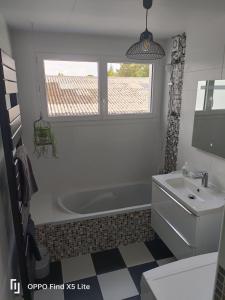 y baño con bañera y lavamanos. en coté jardin, en Questembert