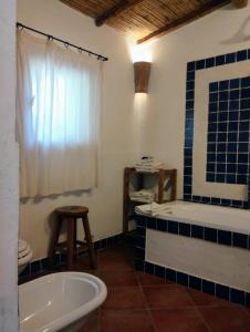 y baño con bañera, aseo y lavamanos. en La Casetta, en Padru