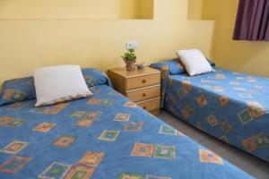 dos camas sentadas una al lado de la otra en un dormitorio en RVHotels Apartamentos Els Salats, en L'Estartit