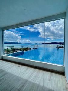 Zimmer mit einem großen Fenster mit Blick auf das Wasser in der Unterkunft Ocean View 611 in Kuah