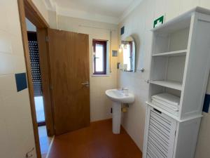 uma pequena casa de banho com um lavatório e um espelho em Home Away From Home em Évora