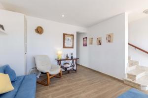 sala de estar con sofá azul y silla en Casa Abril en S'Algar