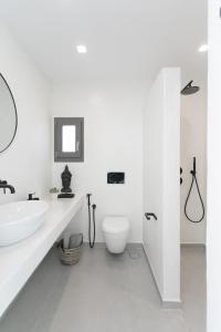 a white bathroom with a sink and a toilet at STONE VILLA NAXOS in Naxos Chora