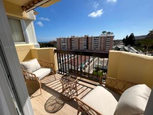 ein Balkon mit Stühlen und Blick auf ein Gebäude in der Unterkunft Selvática Studio Torre del Mar in Torre del Mar