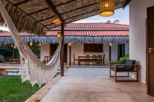 an outdoor patio with a hammock and a house at Villa Estrelas Atins in Atins