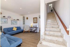 a living room with a blue couch and stairs at Casa Abril in S'Algar