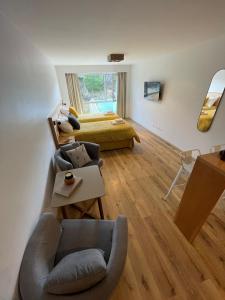uma sala de estar com uma cama, um sofá e uma cadeira em Gente del Sur - Cinco Hermanos em Ushuaia
