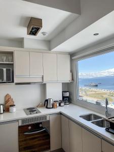 uma cozinha com um lavatório e uma grande janela em Gente del Sur - Cinco Hermanos em Ushuaia
