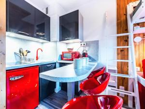 małą kuchnię z czerwonymi krzesłami i stołem w obiekcie Studio rénové au pied des pistes avec balcon à Tignes Le Lac, équipé pour 2, orientation sud - FR-1-502-472 w mieście Tignes
