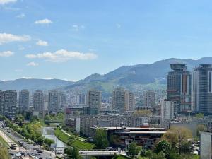 une ville avec de grands bâtiments et des montagnes en arrière-plan dans l'établissement Cityscape Penthouse, à Sarajevo