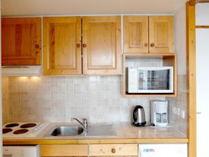 Kuchnia z drewnianymi szafkami, zlewem i kuchenką mikrofalową w obiekcie Appartement lumineux Proche des commerces et des pistes Balcon - FR-1-502-483 w mieście Tignes +6 zdjęć