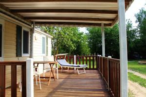 a wooden deck with a table and chairs on a house at Del Falco AgriCamp-12 kilometers to Garda Lake and Verona in Bussolengo