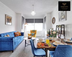 a living room with a table and a blue couch at Luxury Furnished Apartment in Southend-On-Sea by Artisan Stays I Leisure or Business I Free Parking I Sleeps 5 in Southend-on-Sea