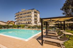 a hotel swimming pool with chairs and a hotel at Hotel King in Marina di Pietrasanta